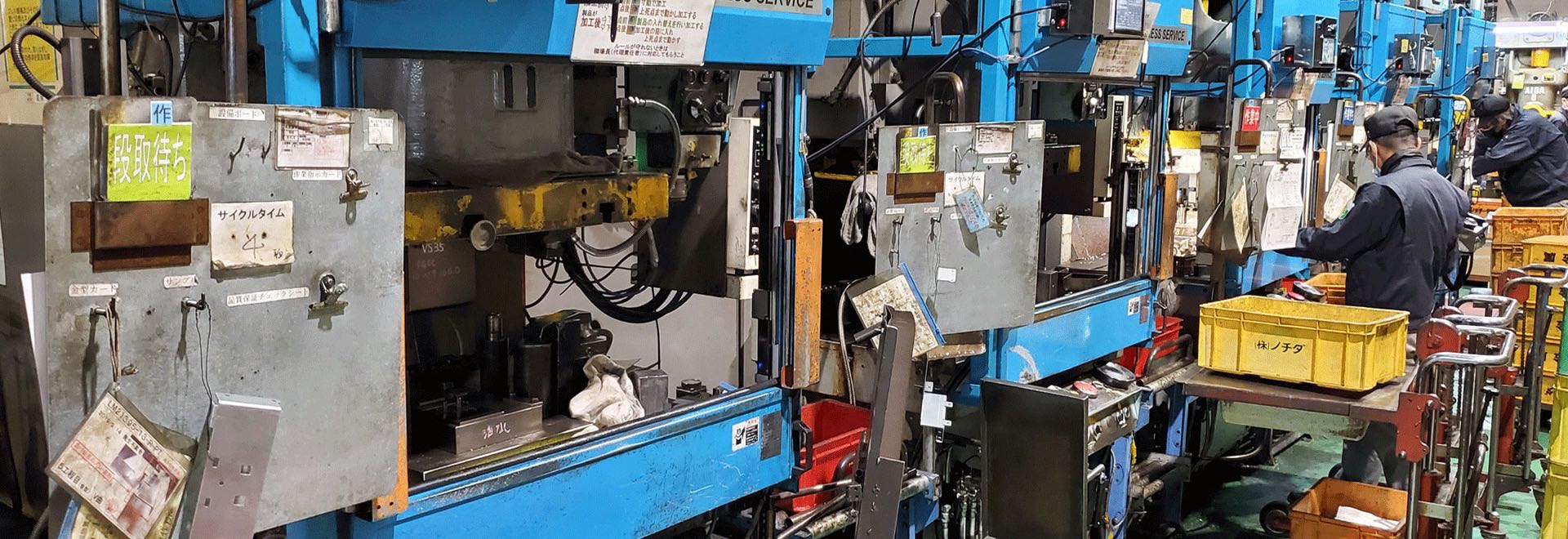 Press machines lined up across a working factory floor